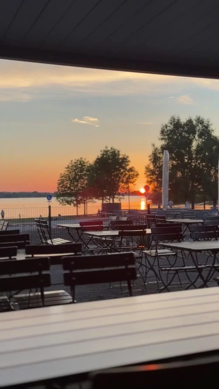 Sonnenuntergang über dem See, gerahmt von der Terrasse